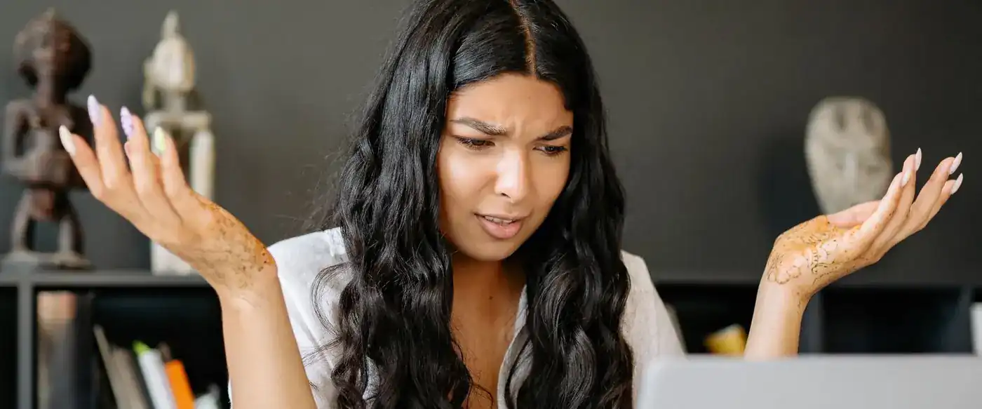 A business owner looking at a laptop with a confused, frustrated expression