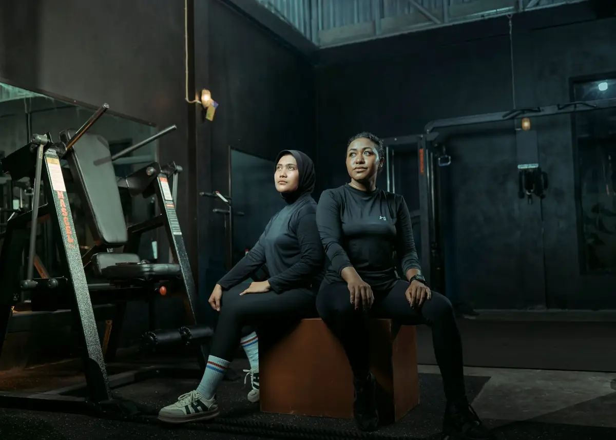 Two coaches in a dark strength gym