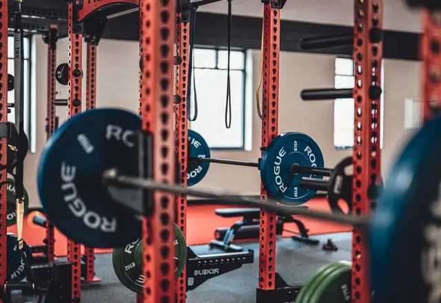 Two coaches in a dark strength gym, from the gym and fitness website template.