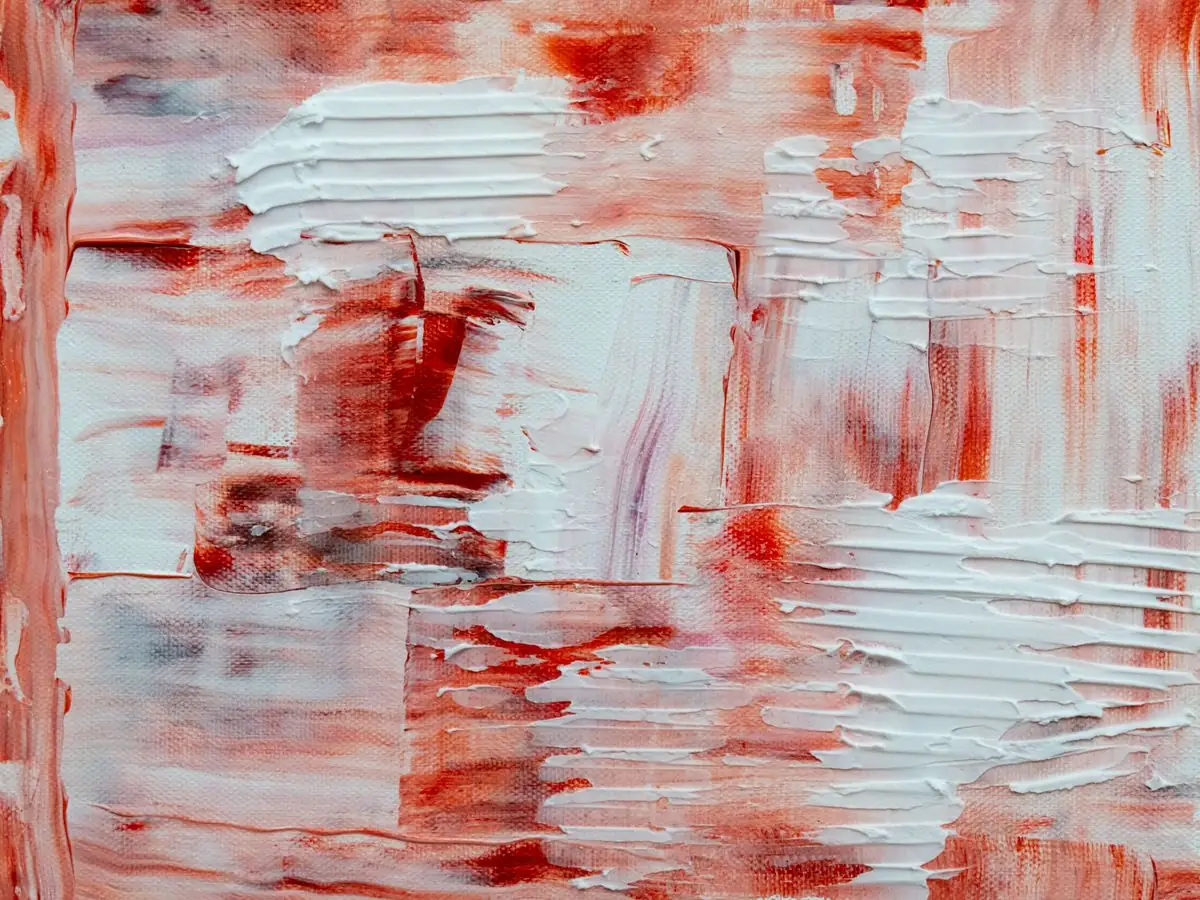 A textured wall of layered brushstrokes in red and white