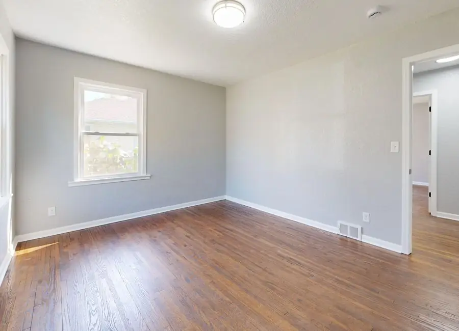 A finished bedroom with restored floors and new windows