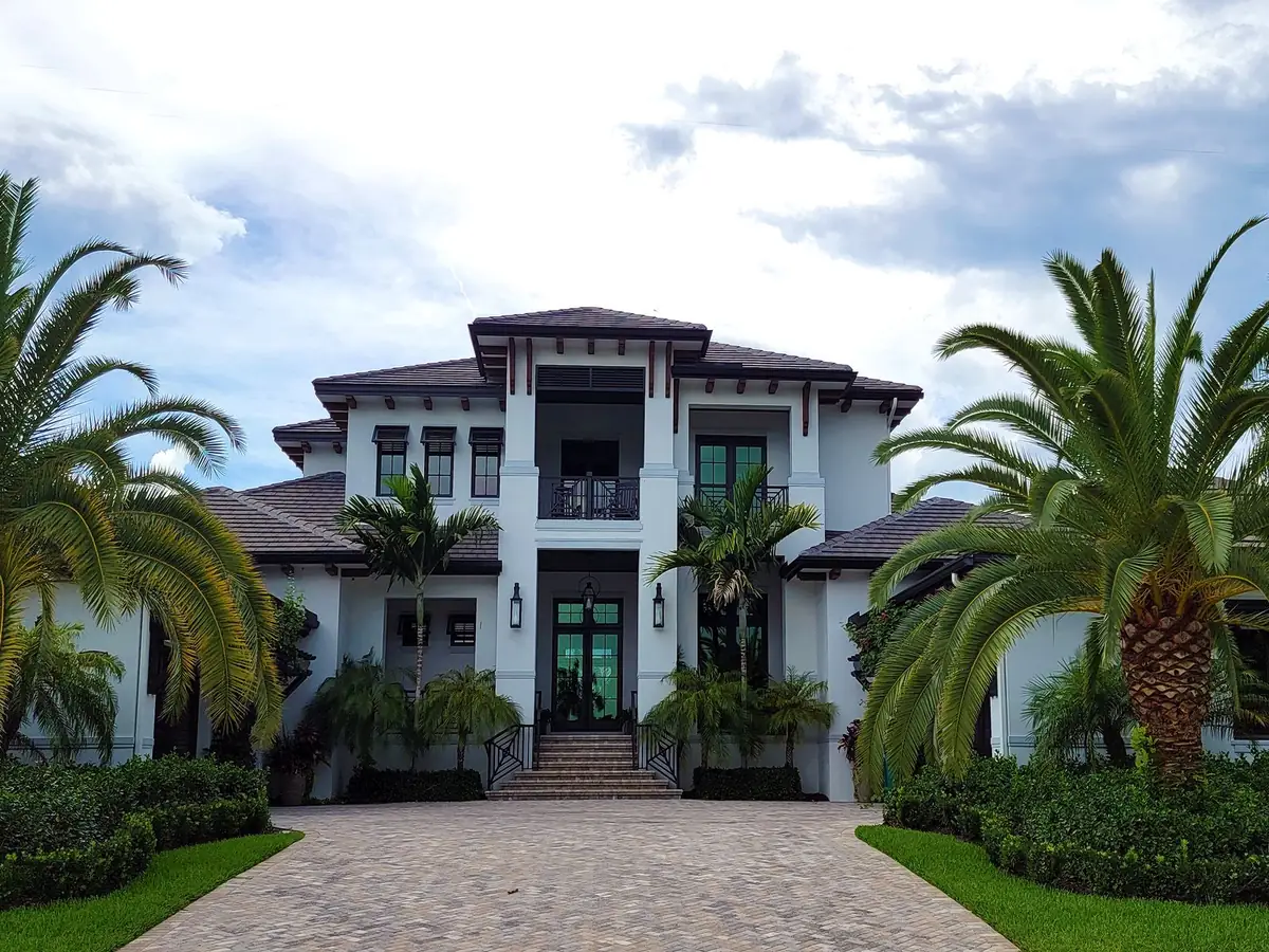 A large white house at the end of a landscaped drive